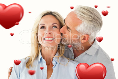 Composite image of affectionate man kissing his wife on the chee