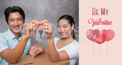 Composite image of happy couple holding house key and leaning on