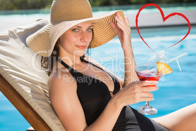 Composite image of beautiful woman holding drink by swimming poo