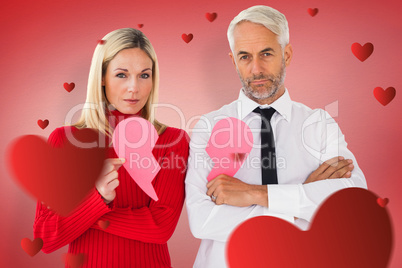 Composite image of couple not talking holding two halves of brok