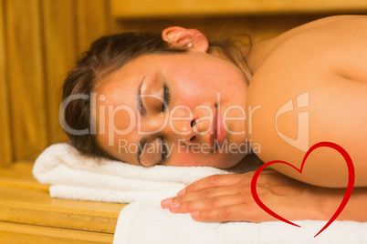 Composite image of smiling brunette lying down in a sauna