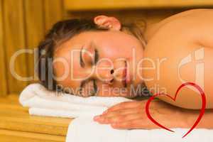 Composite image of smiling brunette lying down in a sauna