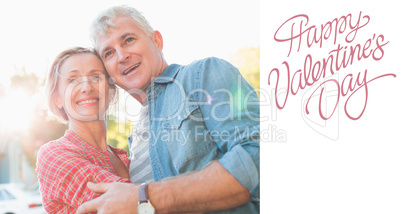 Composite image of happy mature couple hugging in the city