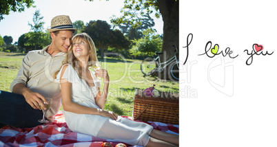 Composite image of cute couple drinking white wine on a picnic s