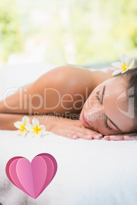 Composite image of beautiful woman lying on massage table at spa
