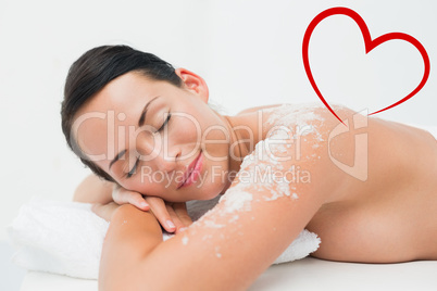 Composite image of peaceful brunette lying with salt scrub on sh