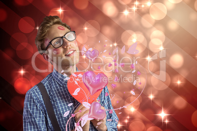 Composite image of geeky hipster covered in kisses