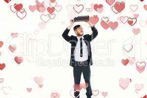 Composite image of geeky businessman holding briefcase over head