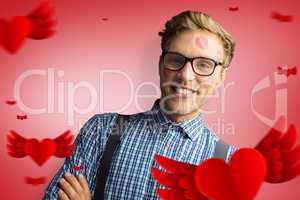 Composite image of geeky hipster covered in kisses