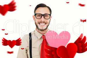 Composite image of geeky hipster smiling and holding heart card