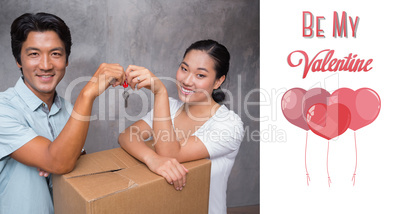 Composite image of happy couple holding house key and leaning on