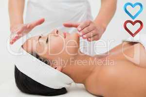 Composite image of peaceful brunette getting reiki therapy