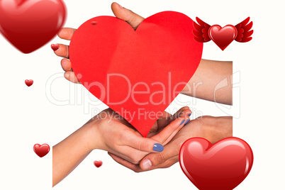 Composite image of hands holding red heart