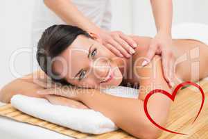 Composite image of beautiful brunette enjoying a shoulder massag