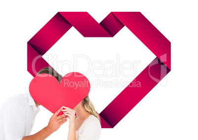 Composite image of attractive young couple kissing behind large