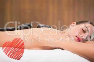 Composite image of beautiful woman receiving stone massage at he