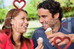 Composite image of two friends laughing while holding ice cream