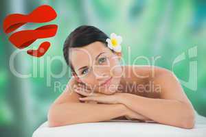 Composite image of beautiful brunette relaxing on massage table