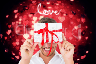 Composite image of man holding gift