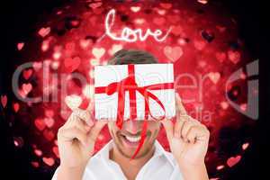 Composite image of man holding gift