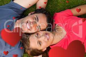 Composite image of two friends looking upwards while lying head