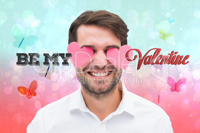 Composite image of handsome man with hearts over his eyes