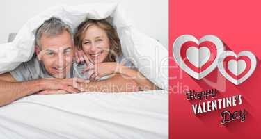 Composite image of cheerful couple under the duvet