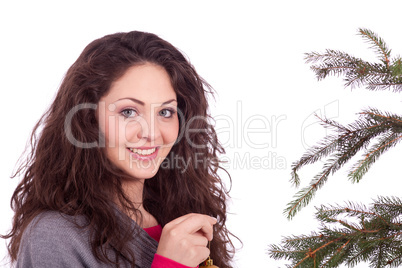 beautiful brunette woman is decorating a christmas tree