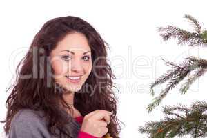 beautiful brunette woman is decorating a christmas tree