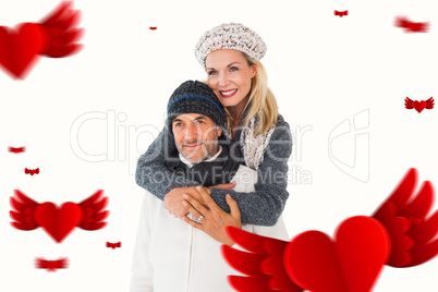 Composite image of happy couple in winter fashion embracing