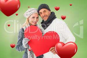 Composite image of smiling couple in winter fashion posing with