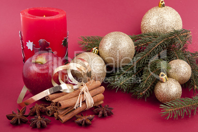 christmas decoration red apple, cinnamon, anise and tree on red background