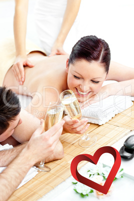Composite image of loving young couple drinking champagne lying Composite image of loving young couple drinking champagne lying