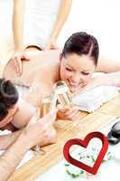 Composite image of loving young couple drinking champagne lying