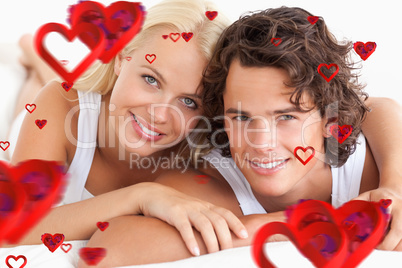 Composite image of couple lying on their bed