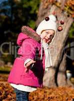 cute littloe girl playing outdoor in autumn