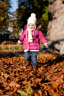 cute littloe girl playing outdoor in autumn