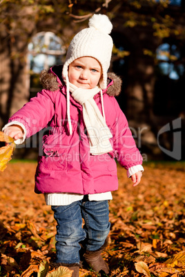 cute littloe girl playing outdoor in autumn