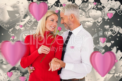 Composite image of handsome man giving his wife a pink rose