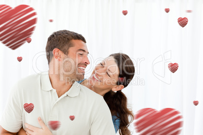 Composite image of lovely couple laughing together in the living