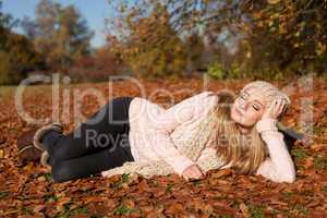 young smiling woman with hat and scarf outdoor in autumn