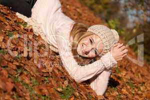 young smiling woman with hat and scarf outdoor in autumn