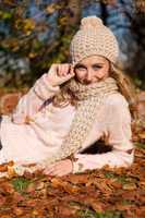 young smiling woman with hat and scarf outdoor in autumn