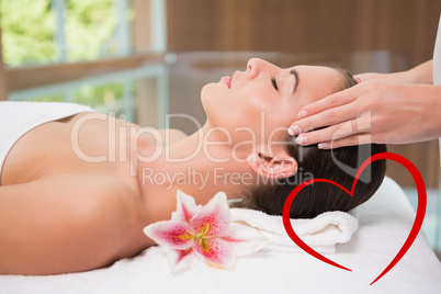 Composite image of attractive woman receiving head massage at sp