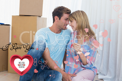 Composite image of couple holding new house key against cardboar