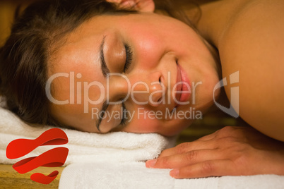 Composite image of happy brunette lying in a sauna