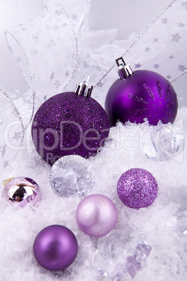 beautiful christmas decoration in purple and silver on white snow