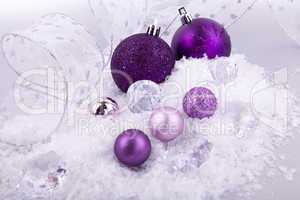 beautiful christmas decoration in purple and silver on white snow