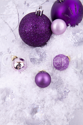 beautiful christmas decoration in purple and silver on white snow