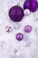 beautiful christmas decoration in purple and silver on white snow